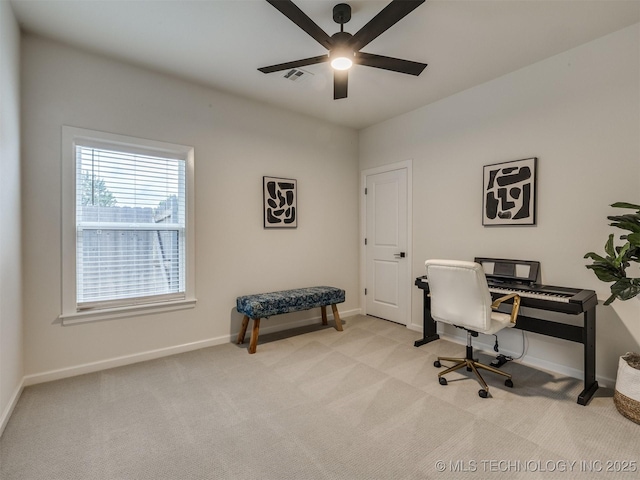 office featuring a ceiling fan, light carpet, and baseboards