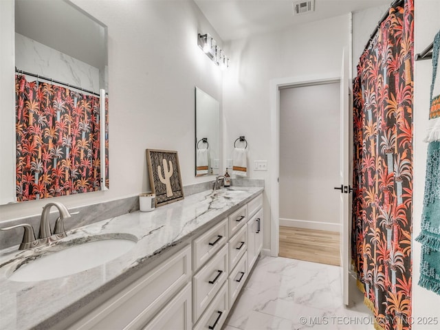 bathroom featuring marble look tile flooring and double vanity