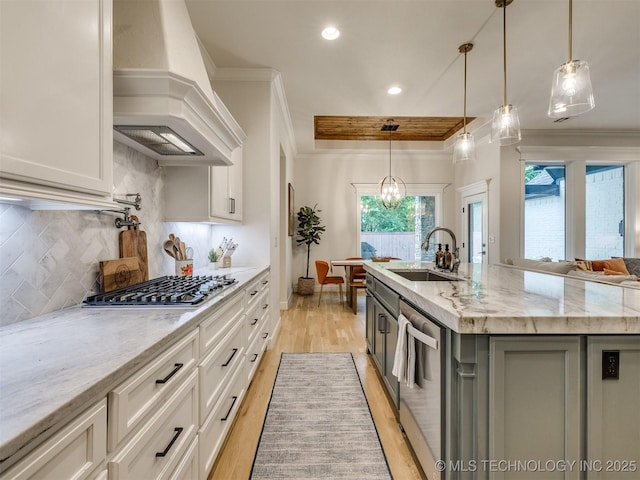kitchen with premium range hood, a sink, stainless steel appliances, crown molding, and light wood-style flooring