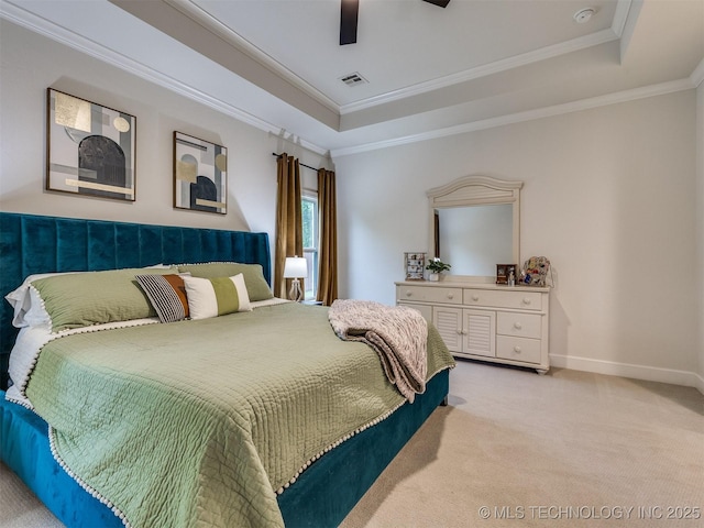 bedroom with a raised ceiling, light colored carpet, crown molding, baseboards, and a ceiling fan