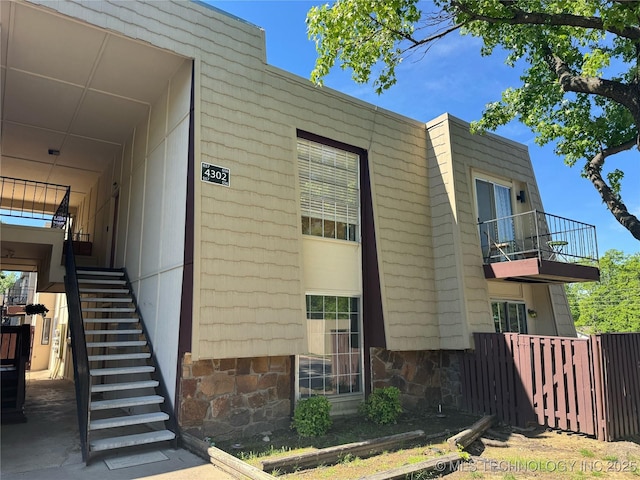 4302 E 67th St Unit 656, Tulsa, OK 74136 - view of side of property featuring stairway, fence, and a balcony