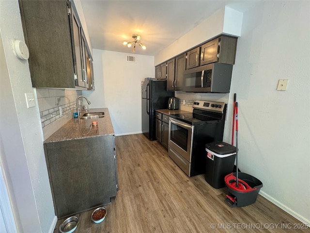 4302 E 67th St Unit 656, Tulsa, OK 74136 - kitchen featuring stainless steel appliances, a sink, light wood-style flooring, and backsplash