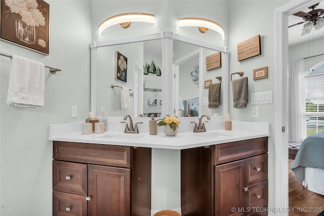 813 Franklin, Ardmore, OK 73401 - full bathroom featuring double vanity, connected bathroom, a ceiling fan, and wood finished floors