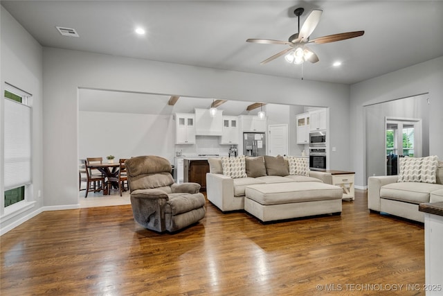 living area with ceiling fan, dark wood finished floors, recessed lighting, baseboards, and vaulted ceiling