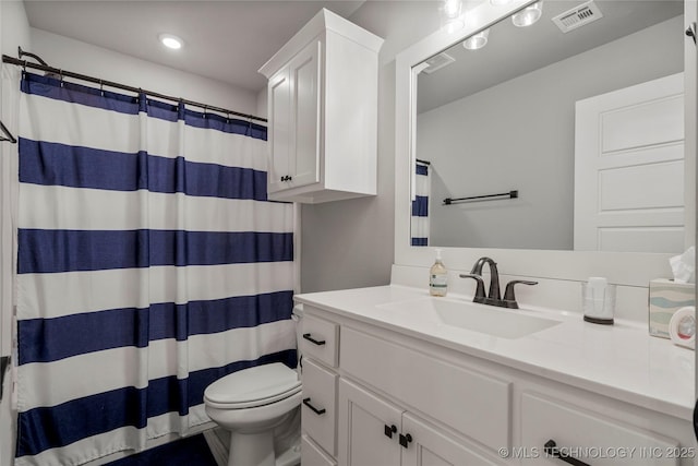 bathroom featuring toilet, vanity, a shower with curtain, and recessed lighting