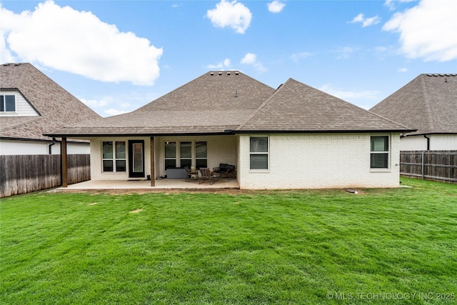 rear view of house featuring roof with shingles, brick siding, and a patio
