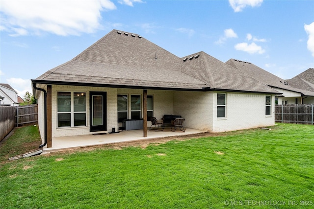 rear view of house with brick siding, a shingled roof, and a patio area