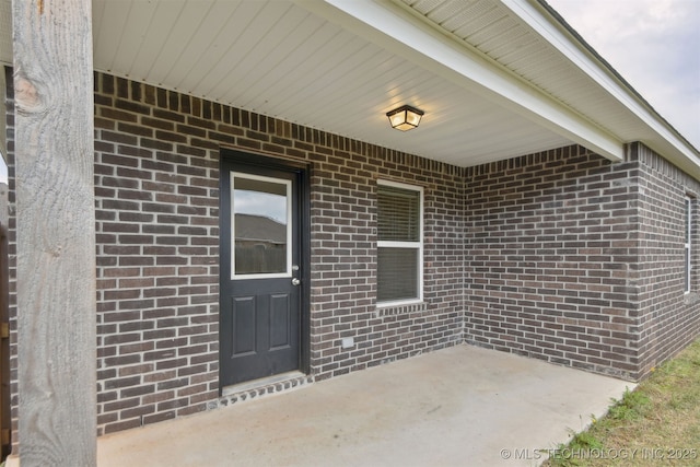 7535 E 158th St S, Bixby, OK 74008 - doorway to property featuring brick siding and a patio area