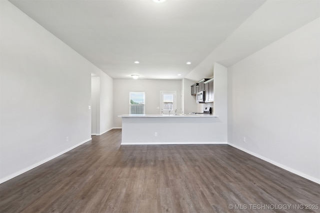 7535 E 158th St S, Bixby, OK 74008 - unfurnished living room featuring dark wood-type flooring, baseboards, and recessed lighting