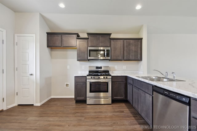 7535 E 158th St S, Bixby, OK 74008 - kitchen featuring stainless steel appliances, a sink, dark brown cabinets, dark wood-style floors, and recessed lighting