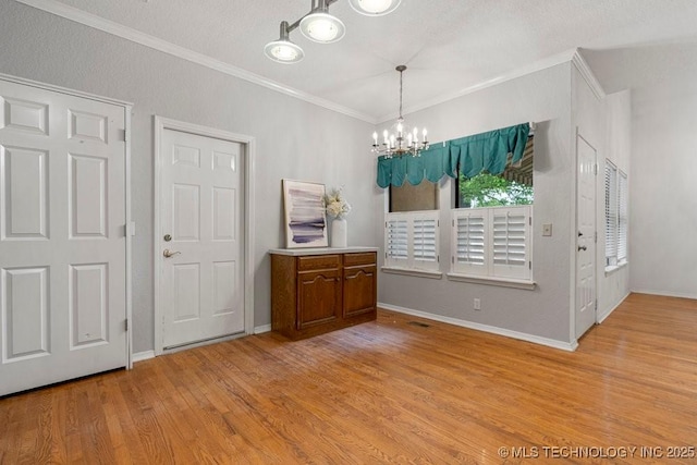 dining area with a chandelier, ornamental molding, light wood-type flooring, and baseboards