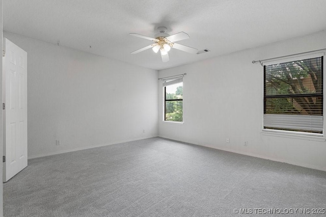 carpeted spare room with ceiling fan and baseboards