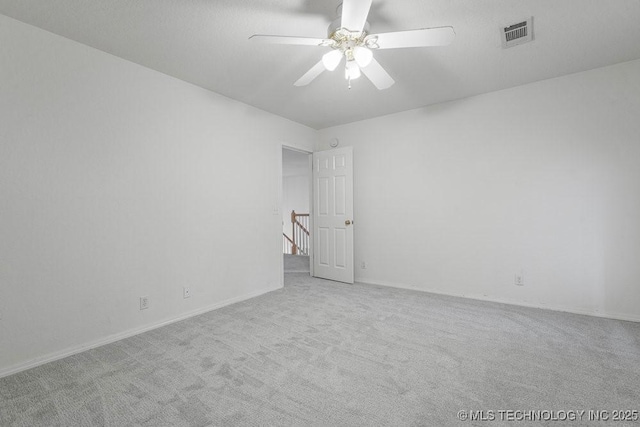 empty room with carpet flooring, ceiling fan, and baseboards