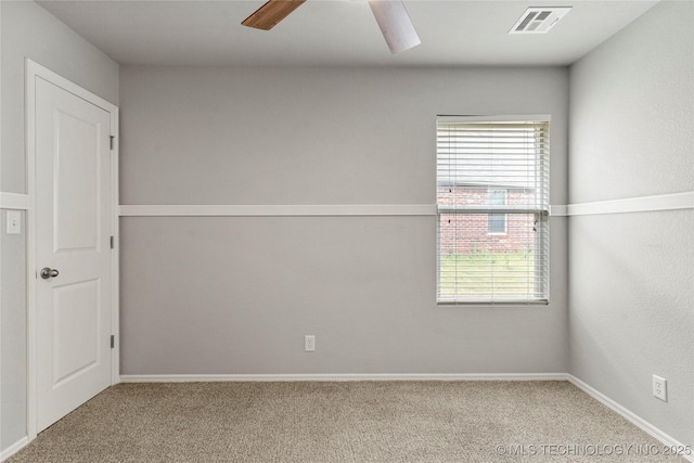 empty room with carpet floors, a ceiling fan, and baseboards