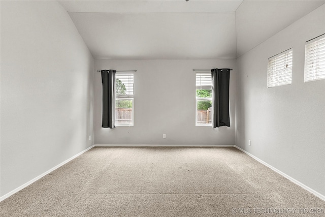 unfurnished room with vaulted ceiling, carpet floors, and baseboards