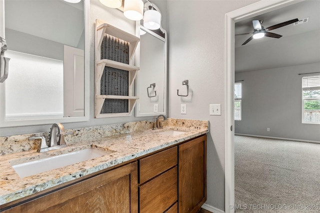 full bathroom with double vanity, ceiling fan, and baseboards