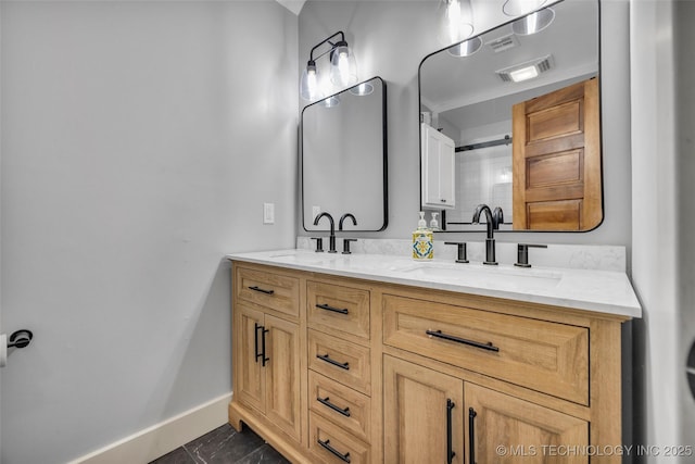 bathroom featuring baseboards and double vanity