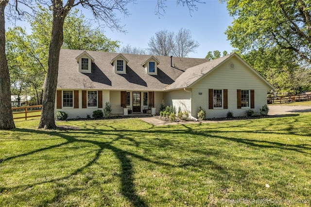 new england style home featuring brick siding and roof with shingles