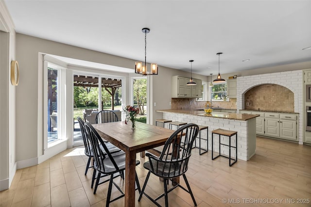 dining space featuring a chandelier and baseboards