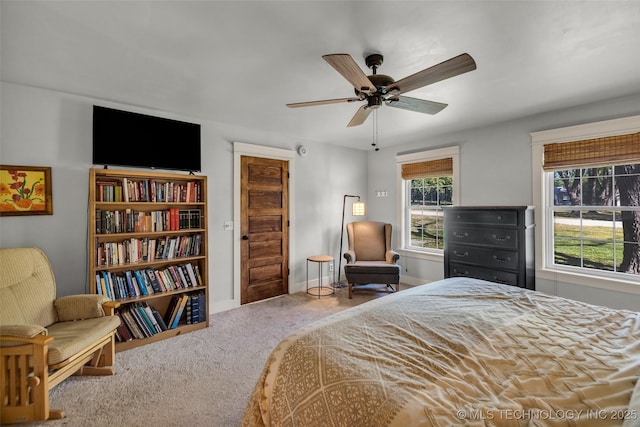 carpeted bedroom featuring baseboards and a ceiling fan