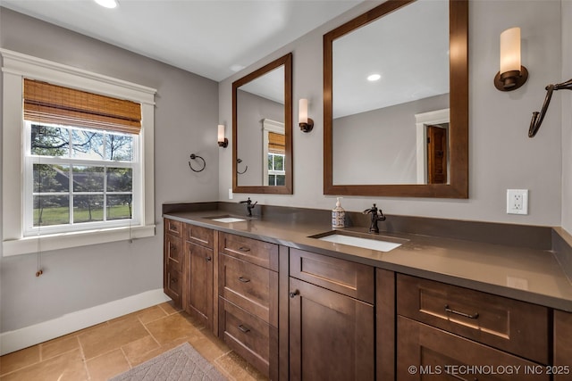 full bath featuring baseboards, double vanity, and recessed lighting