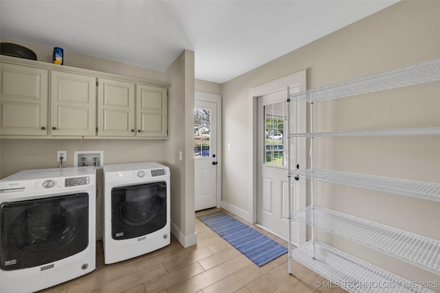 laundry area with cabinet space, separate washer and dryer, wood tiled floors, and baseboards