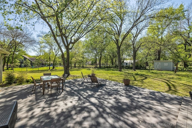 view of patio / terrace featuring outdoor dining area, a shed, and an outdoor structure