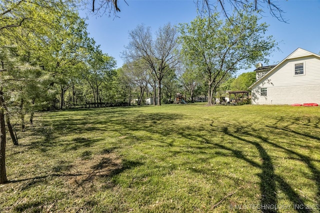 view of green lawn featuring a playground