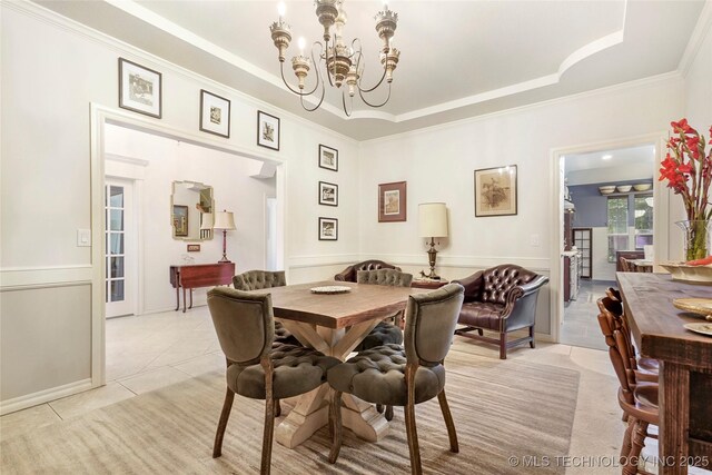 dining area with a chandelier, light tile patterned floors, ornamental molding, and a tray ceiling