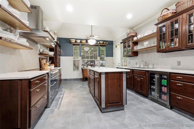 kitchen with open shelves, wine cooler, stainless steel stove, island exhaust hood, and recessed lighting