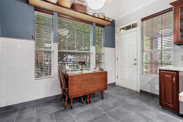 dining room featuring ornamental molding and dark tile patterned floors