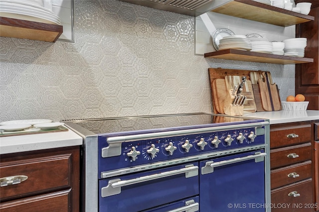 kitchen with double oven range, open shelves, and light countertops