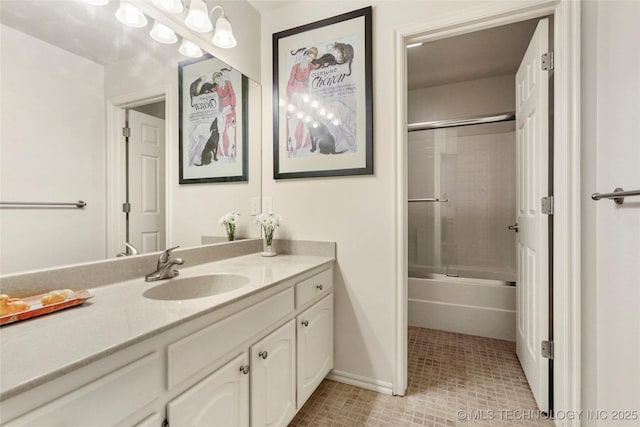 bathroom featuring tile patterned floors, vanity, combined bath / shower with glass door, and baseboards