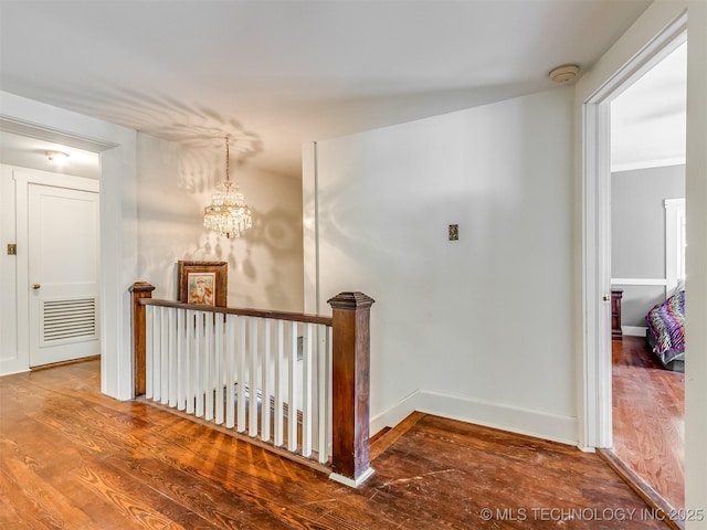 2831 S 24th St W, Muskogee, OK 74401 - corridor featuring wood finished floors, an upstairs landing, a chandelier, and baseboards