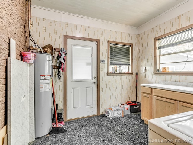2831 S 24th St W, Muskogee, OK 74401 - kitchen with electric water heater, crown molding, wallpapered walls, carpet, and light brown cabinetry