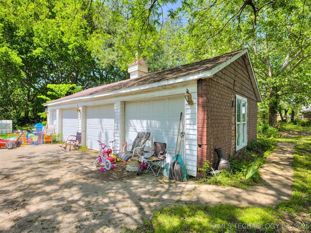 2831 S 24th St W, Muskogee, OK 74401 - detached garage featuring view of wooded area