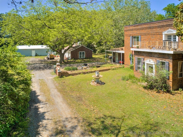 2831 S 24th St W, Muskogee, OK 74401 - view of green lawn with dirt driveway, an outbuilding, and a balcony