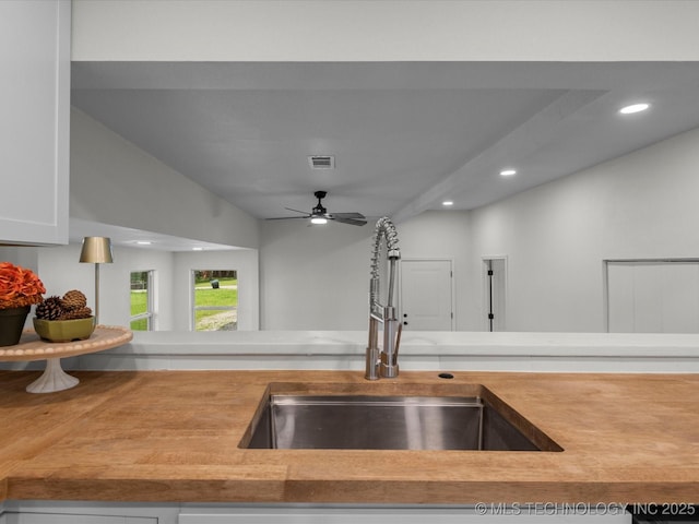 kitchen view of a sink, a ceiling fan, recessed lighting, white cabinetry, and light countertops