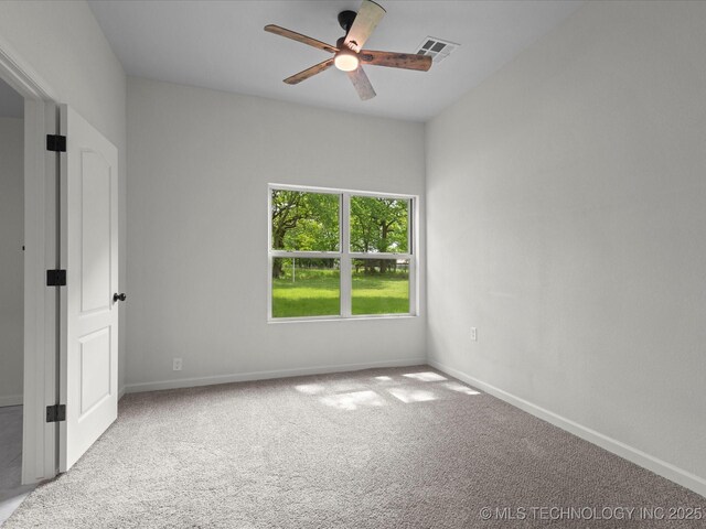 carpeted spare room featuring ceiling fan and baseboards