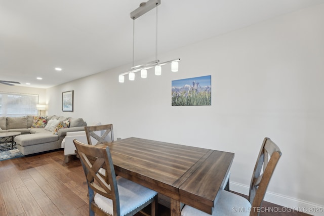 dining room featuring dark wood-type flooring, recessed lighting, and baseboards