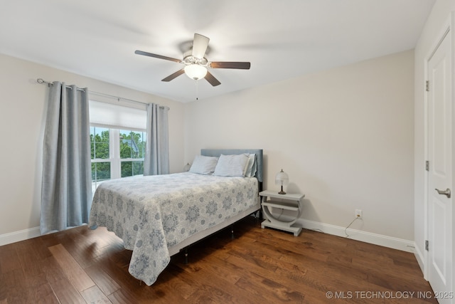 bedroom featuring baseboards, wood finished floors, and a ceiling fan