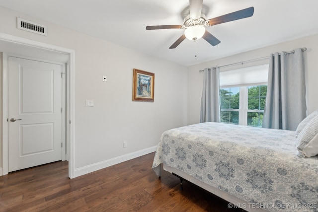 bedroom with baseboards, dark wood-style floors, and a ceiling fan