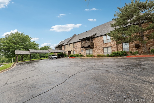 view of property featuring covered and uncovered parking