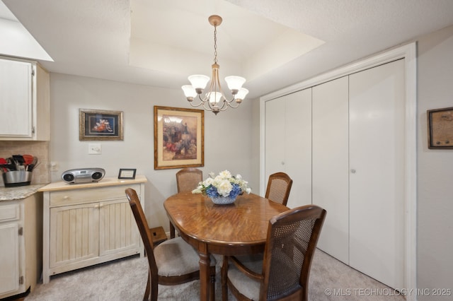 6522 S Memorial Dr Unit 19-H, Tulsa, OK 74133 - dining room with light carpet, a chandelier, and a raised ceiling