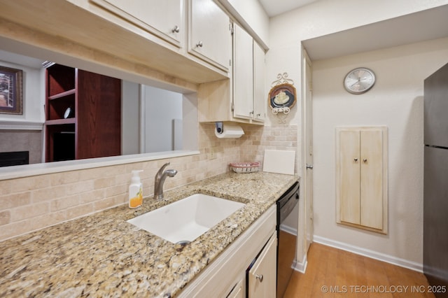 6522 S Memorial Dr Unit 19-H, Tulsa, OK 74133 - kitchen with a sink, dishwashing machine, tasteful backsplash, baseboards, and light wood-style floors