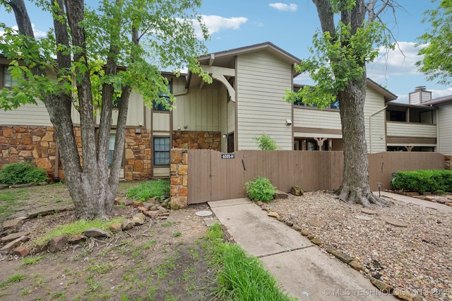 6522 S Memorial Dr Unit 19-H, Tulsa, OK 74133 - view of front of home featuring stone siding and a gate