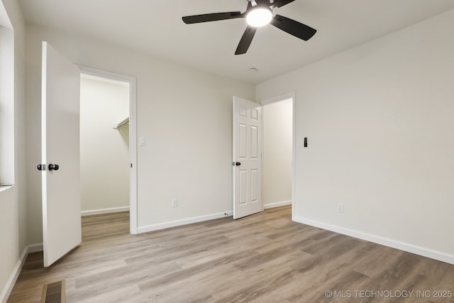 1901 W Indianola St, Broken Arrow, OK 74012 - unfurnished bedroom featuring light wood-style flooring, a walk in closet, baseboards, and ceiling fan