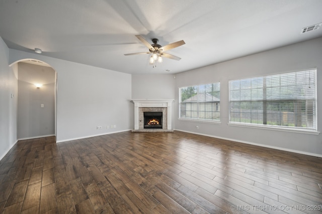 4025 S 217th E Ave, Broken Arrow, OK 74014 - unfurnished living room with ceiling fan, dark wood finished floors, a fireplace, baseboards, and arched walkways