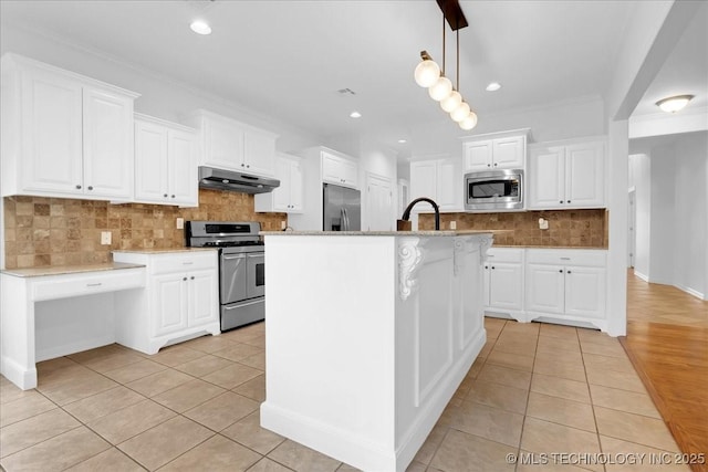 kitchen with appliances with stainless steel finishes, under cabinet range hood, light tile patterned flooring, tasteful backsplash, and white cabinets