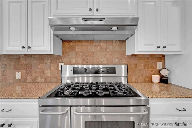 kitchen with stainless steel range with gas stovetop, under cabinet range hood, white cabinetry, and backsplash